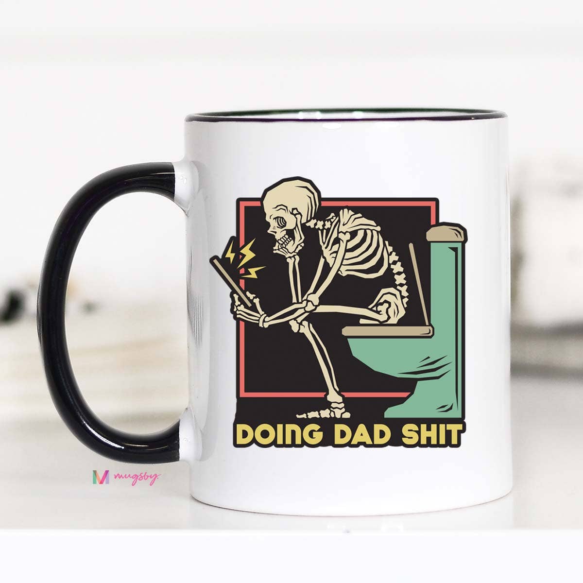 A ceramic coffee mug with a black rim and handle, featuring a graphic print of a skeleton holding a cell phone and the text 'DOING DAD SHIT'.